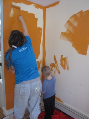 Leah and Zion painting the playroom walls orange