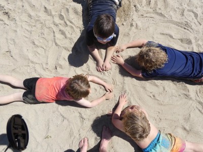 kids lying on the sand at Freeman Pond