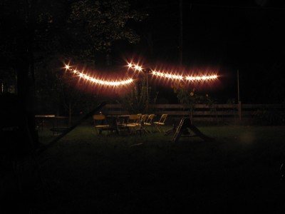 the globe lights hanging over the empty picnic table