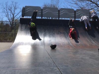 Zion and Elijah sliding head-first down a halfpipe
