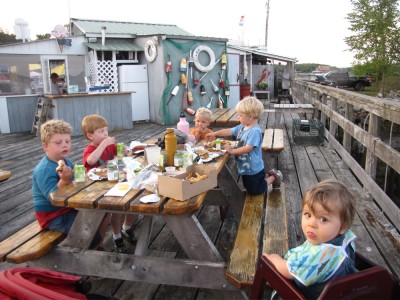 five boys eating supper on the pier