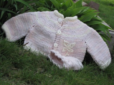 pink cotton baby sweater in garden