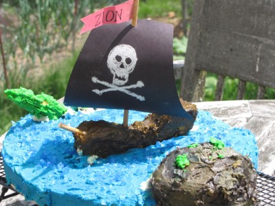 a cake: blue sea with island, sea monster, and pirate ship