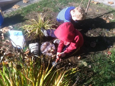 Zion and Lijah planting bulbs in the front yard