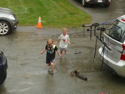 Lijah and Henry running on the street in the steady rain