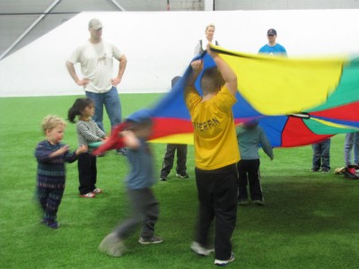 the boys playing with a parachute with some other kids