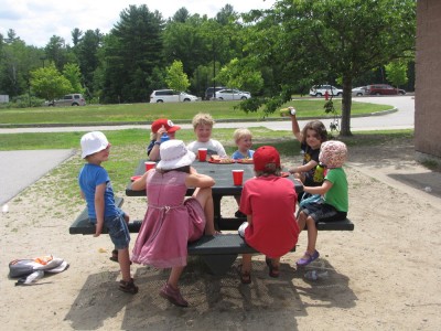 some of the kids sitting around a table on the playground