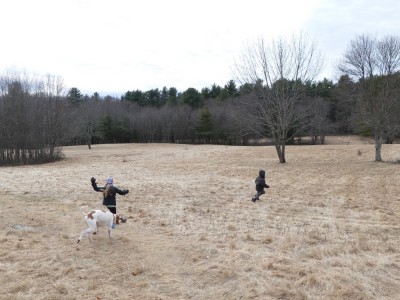 Lijah running in a field with a friends and her dog