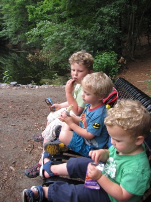 the boys sitting on a bench eating their hiking snack