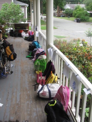 many backpacks lined up along the edge of the porch