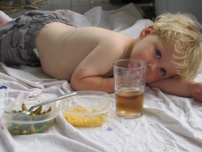 shirtless Zion lying on the blanket with his food