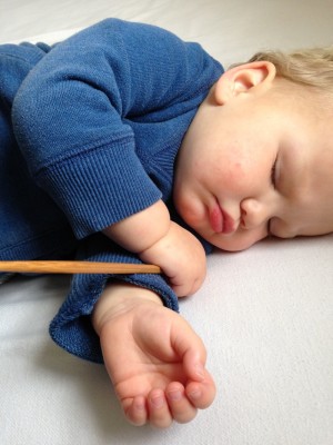 Lijah asleep, clutching his chopstick