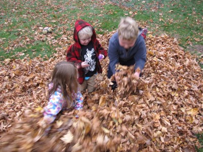 Harvey, Zion, and Taya digging for prizes in the leaf pile