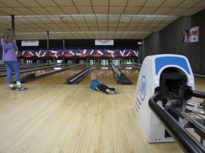 Zion lying down to watch his ball hitting the pins