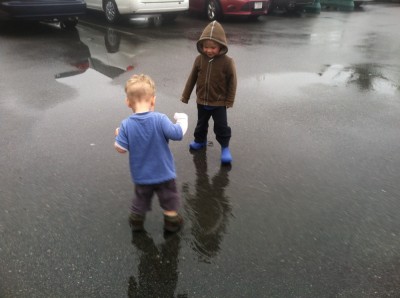 Zion and Lijah looking for puddles in a parking lot