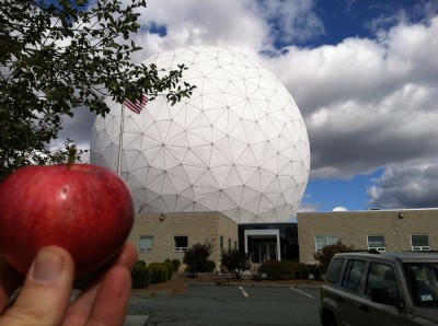 me holding a red apple in front of the Haystack Radio Telescope