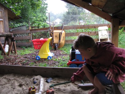 Harvey playing in the sandbox in the rain
