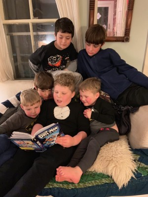 Harvey reading Dog Man to brothers and friends