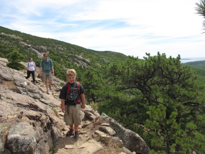 Harvey, Kyle, and Margaret hiking a steep-sided trail on Hugonaut Head