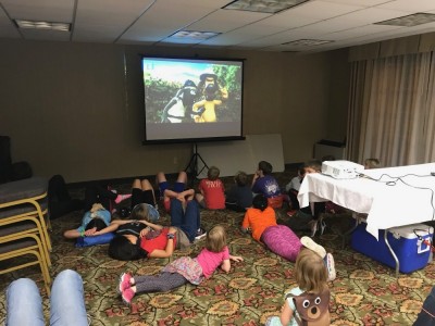 kids watching Shaun the Sheep in a conference room