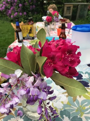 a bouquet of rhododendron and wisteria flowers on the picnic table