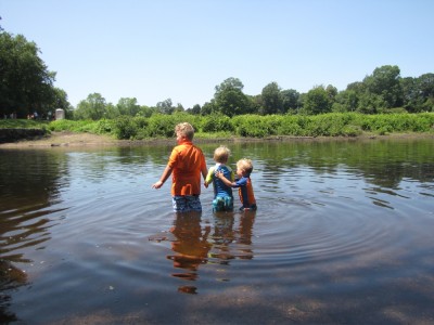 the three boys wading in the river