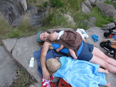 Archibalds sleeping on a shady rock: Zion wrapped in towels, and Leah lying with Lijah in the Ergo