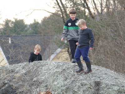 Zion, Lijah, and Matthew atop a big rock by the Lexington bell-tower