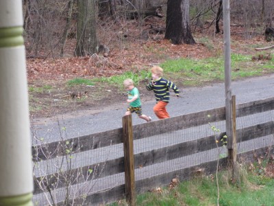 Zion and Nathan running on the street, seen from the porch