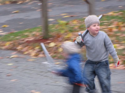 Zion and Harvey running in the street with their swords
