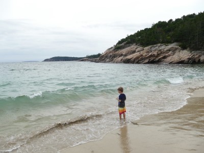 Elijah standing at the water's edge at Sand Beach