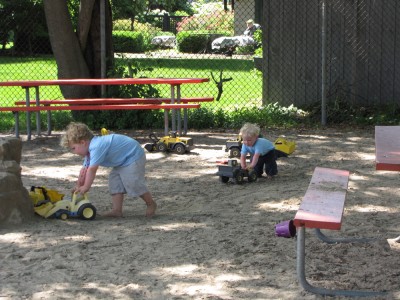 Harvey and Zion pushing sand toys at the Emerson Park playground