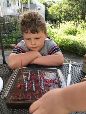 Harvey admiring the birthday cake he decorated for himself with Grandma
