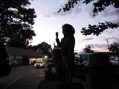 Zion and Harvey silhouetted against the evening sky at the ice cream store
