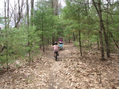 Harvey and Mama (carrying Zion and Lijah) riding on a path through the woods