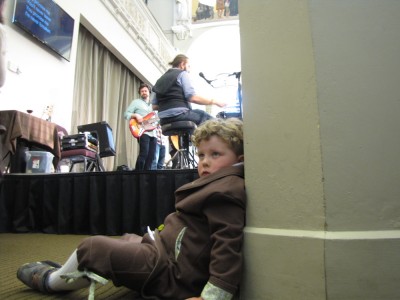 Harvey leaning against a column beside the stage
