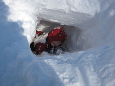 Harvey climbing up through a hole in the snowbank