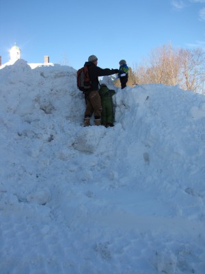 Dan, Harvey, and Zion climbing a giant mountain of snow