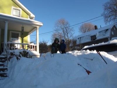 Zion and Harvey atop a giant pile of snow in front of our porch