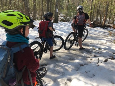 the boys pausing on their bikes on a snowy trail