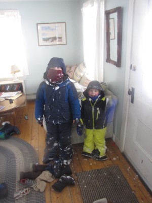 Harvey and Zion just inside the front door, still geared up and covered with snow