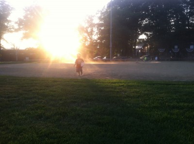 Lijah running across the dusty softball field at sunset
