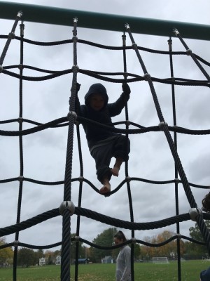 Lijah climbing a tall rope ladded structure
