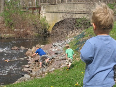 Harvey and Zion poking around a creek, Lijah looking on
