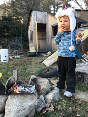 Lijah licking his fingers after eating a smore by the fire