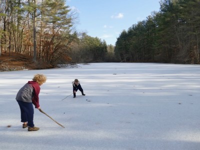Harvey and Zion on the pond playing hockey with sticks