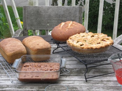 breads, a pie, and brownies on the table outside