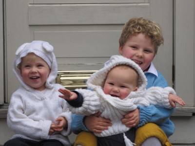 the three boys--Harvey holding Lijah--posing in their new sweaters on Grandpa's front steps