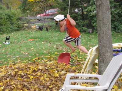 Harvey swinging on a rope into the leaf pile