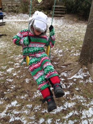 Harvey in fuzzy PJs and winter hat on the swing